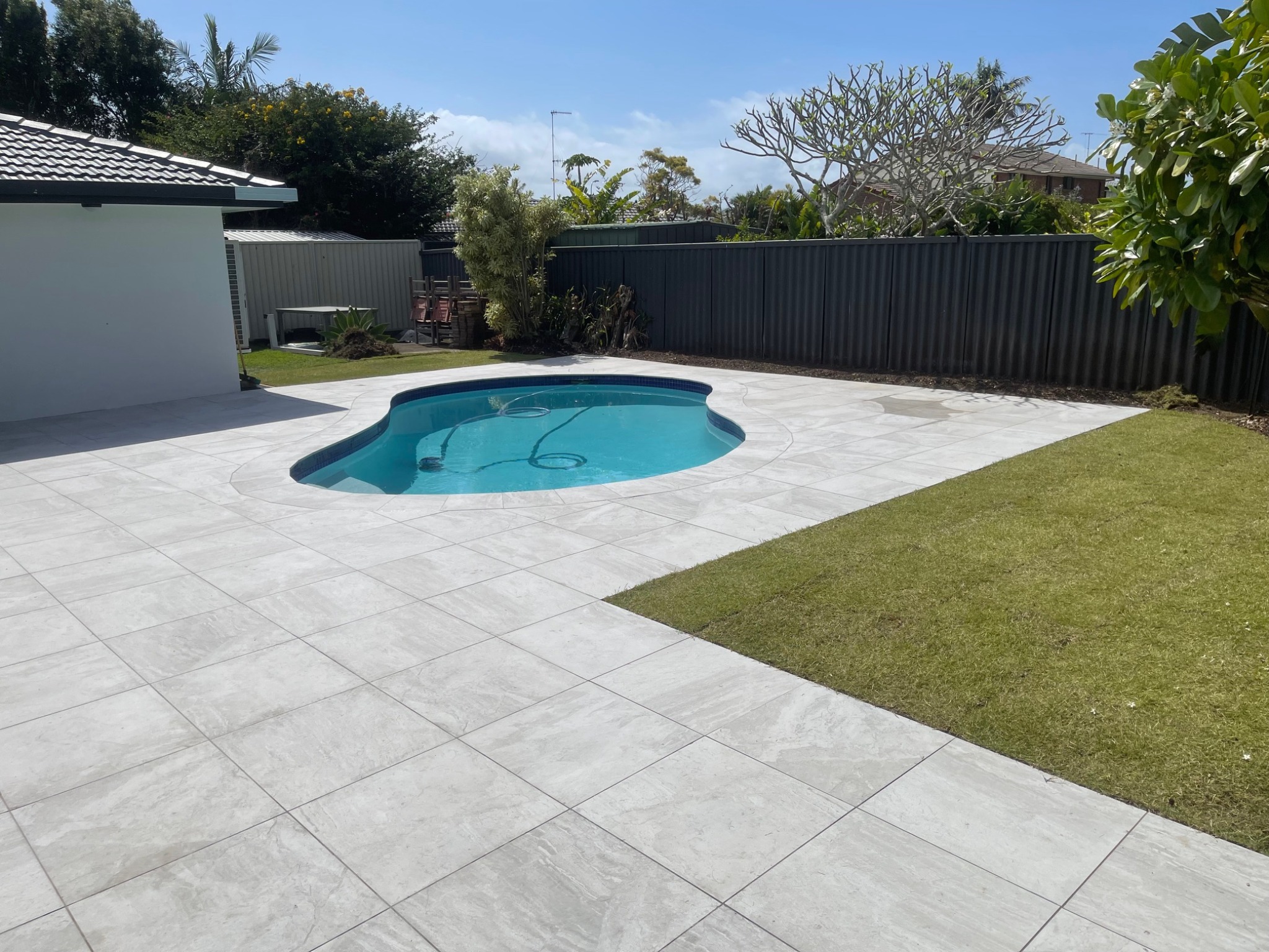 Pool area with large format tiles and lawn